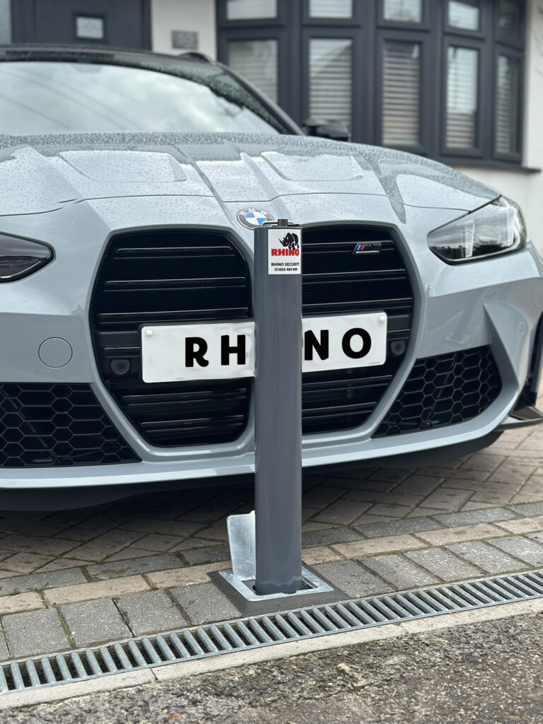 Telescopic bollard at end of driveway with silver BMW car behind it