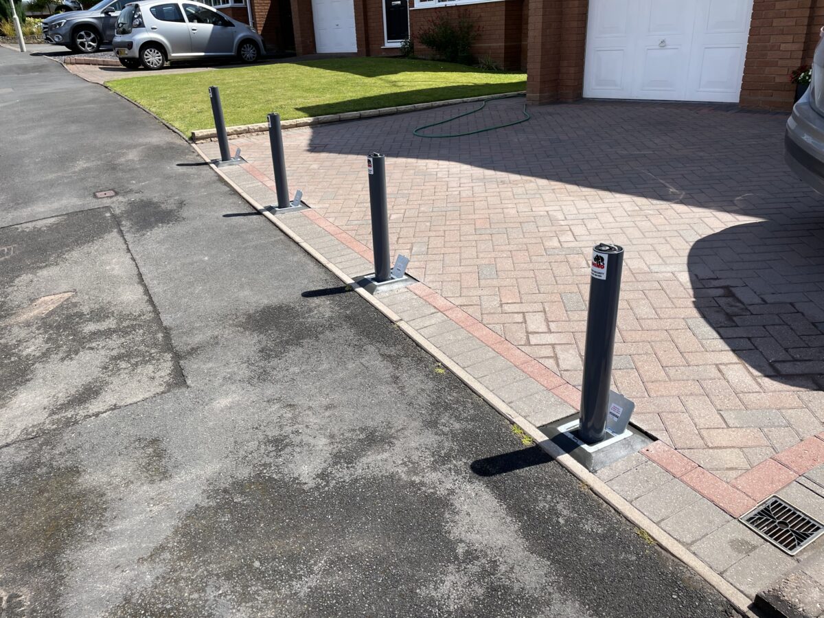 Four telescopic bollards in place at the end of a house's driveway